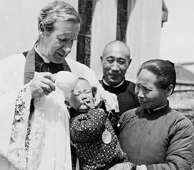 Fr. Edward Galvin baptizing an infant